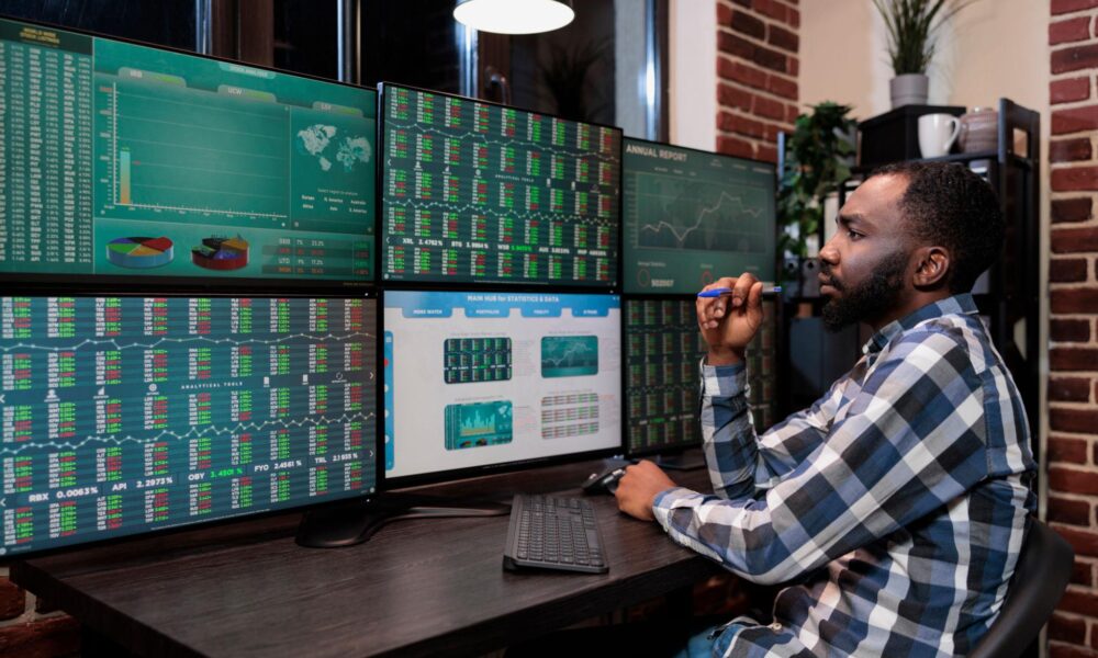 trader analisando fluxo de mercado em múltiplas telas com foco em leitura de agressão